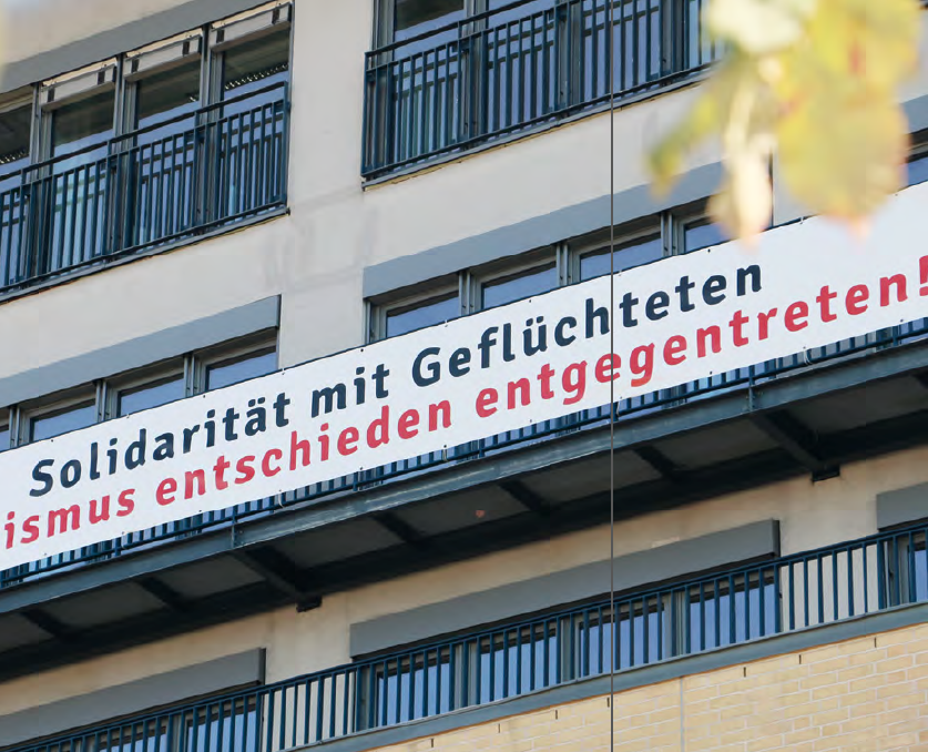 Ein Banner an der Fassade der Alice Salomon Hochschule mit der Aufschrift: "Solidarität mit Geflüchteten. Rassismus entschieden entgegentreten!"